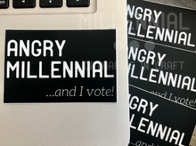 Load image into Gallery viewer, A black rectangular vinyl sticker that reads “Angry Millennial” in large bold font with small, italicized font on the bottom right corner that reads, “…and I vote!” All lettering is in white.
